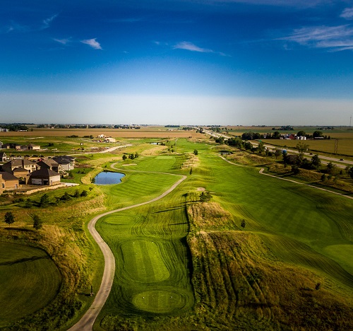 Fairway view of manicured golf course and cart path