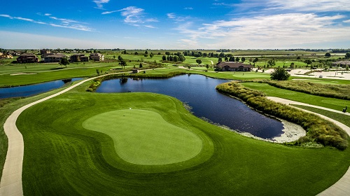 Aerial view of cart path and pond on golf course 