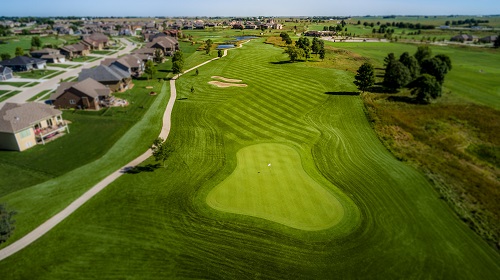 View of golf course with cart path and trees