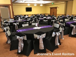 Black and purple banquet reception seating with silver bows on the backs of chairs