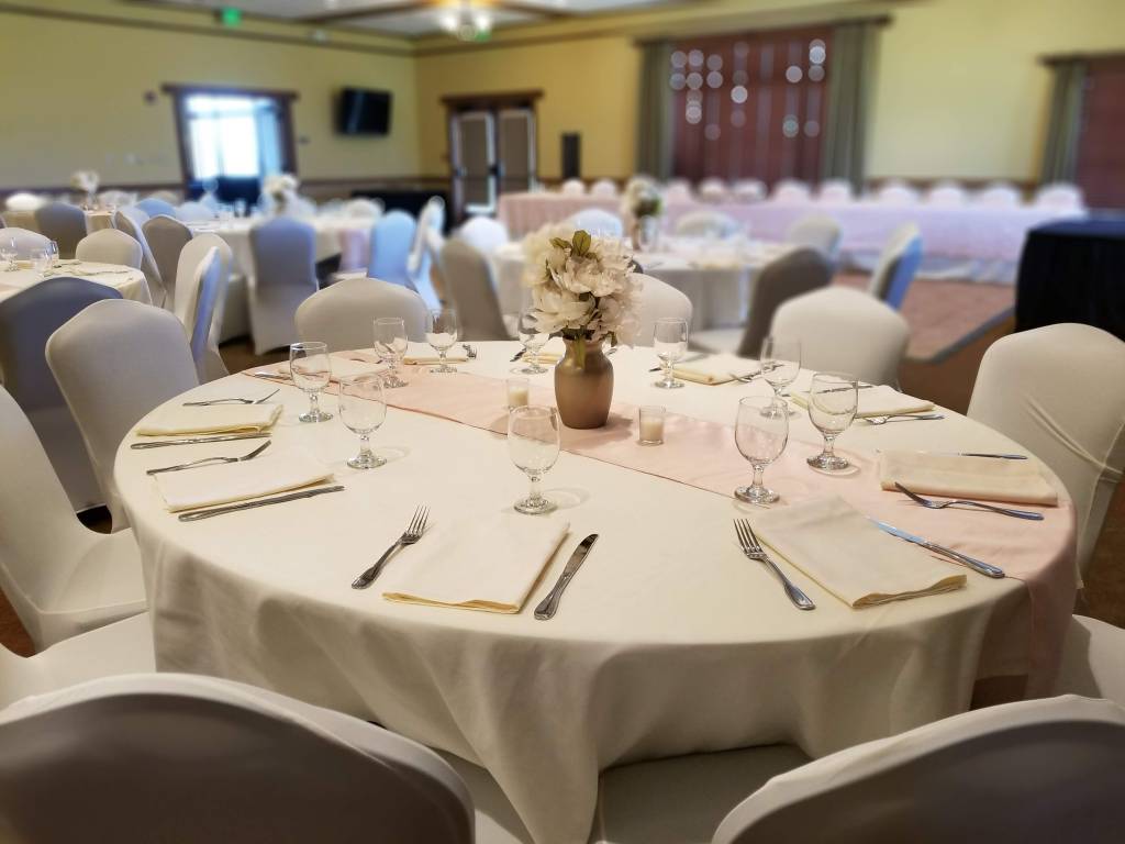 Banquet table at wedding reception with pale pink decor and flowers