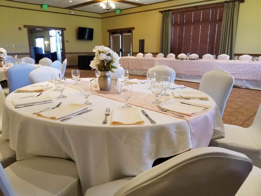 White banquet reception seating with flower centerpiece